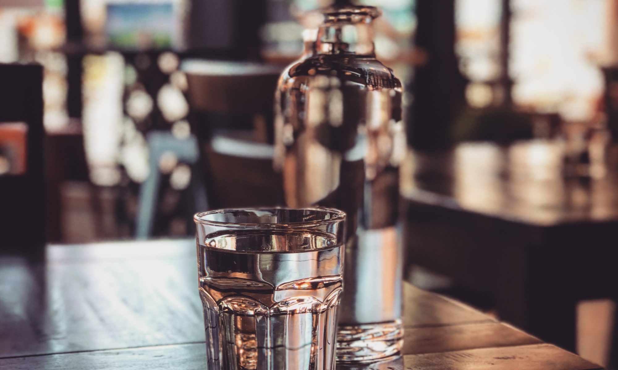 Glass and bottle of water on table.